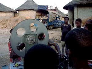 Préparation du projecteur sous le regard des enfants du village
